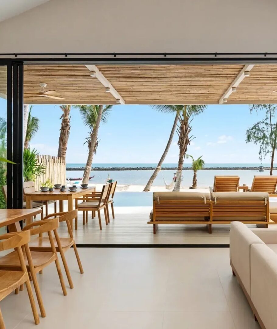 Open seaside room with wooden furniture.