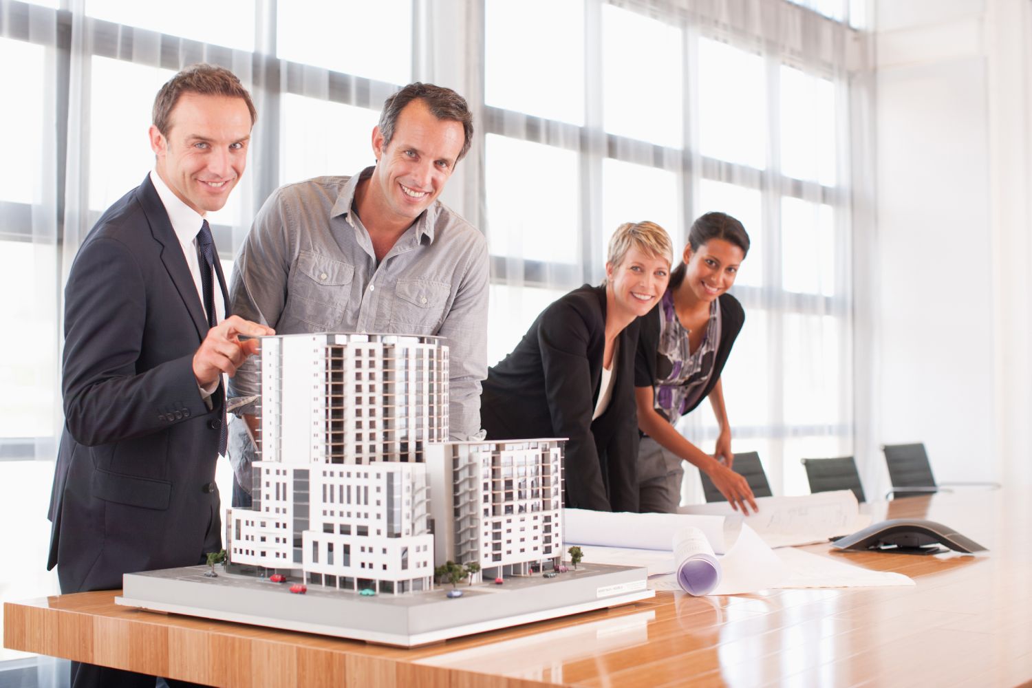 Architects with building model and blueprints.