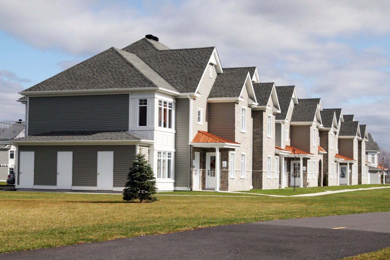 Row of suburban houses under cloudy sky.