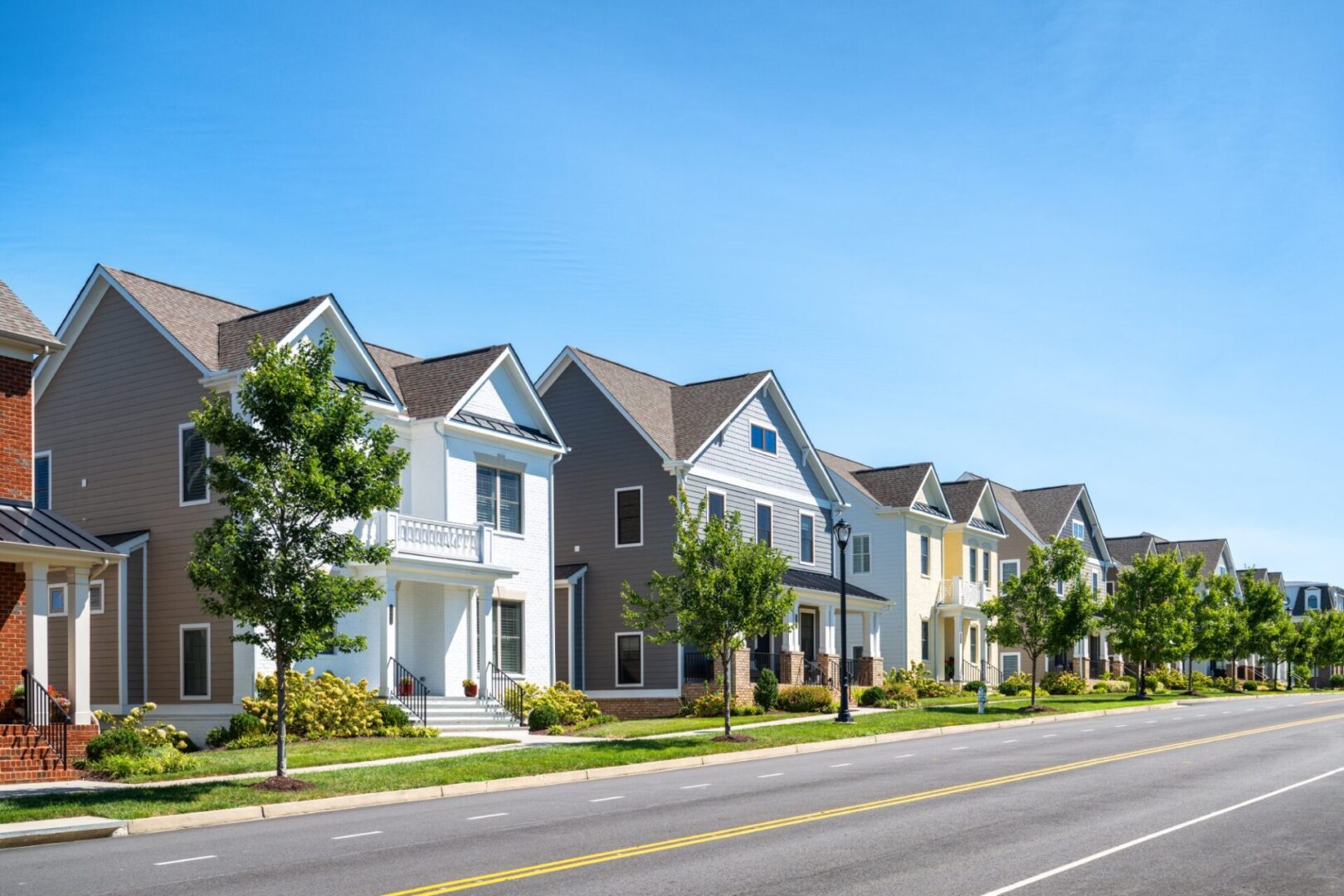 Suburban street with modern houses and trees.