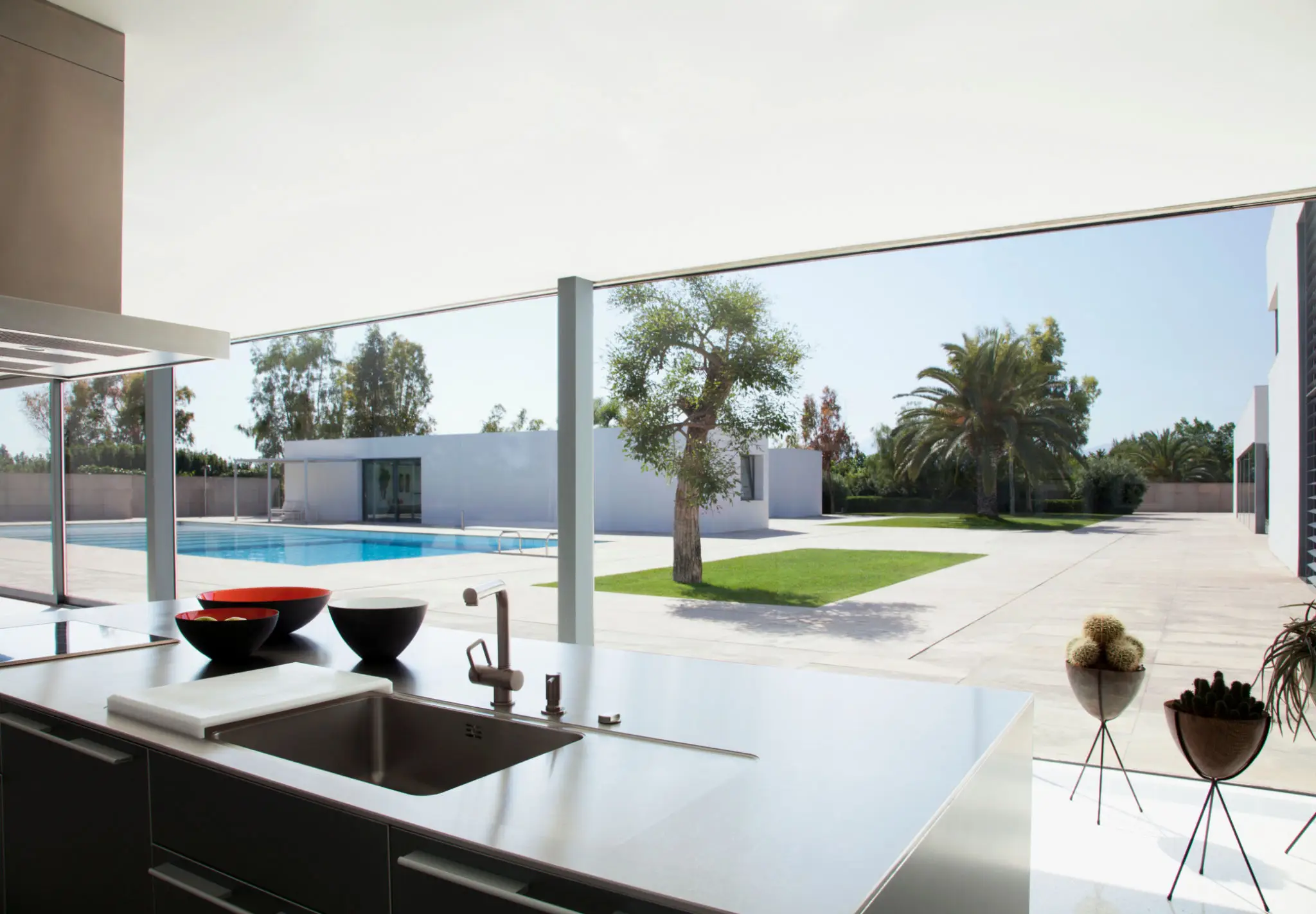Modern kitchen overlooking pool and garden area.